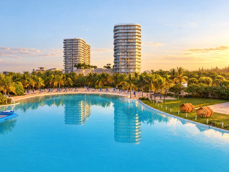 A large swimming pool in the foreground with two buildings in the background.